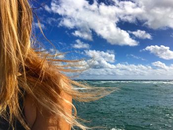 Close-up of woman at beach against sky