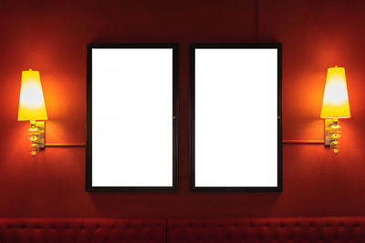 Illuminated lamp on wall at home