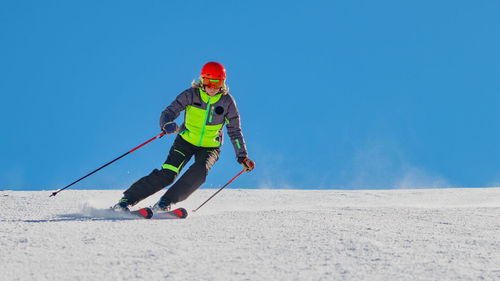 Woman skiing on snow against sky