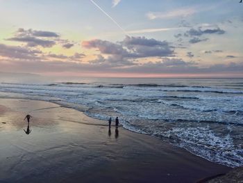 Scenic view of beach against cloudy sky