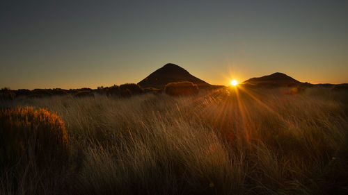 Scenic view of land against sky during sunset