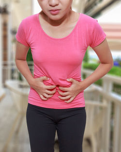 Midsection of woman with pink hair standing outdoors