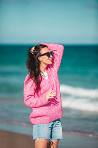 Rear view of woman standing at beach