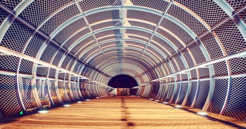 View of footbridge in illuminated tunnel