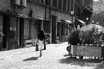 Rear view of woman walking on footpath