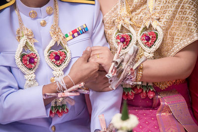 Midsection of couple wearing traditional clothing during wedding ceremony