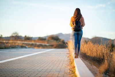 Rear view of woman standing against sky