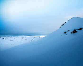 Scenic view of snow covered mountains against sky