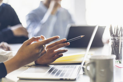 Midsection of woman using laptop on table