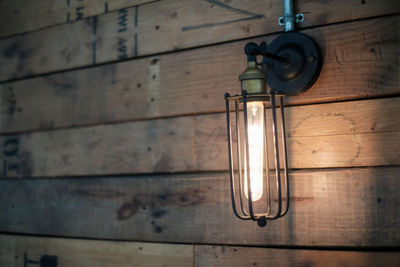 Low angle view of light bulb hanging on wall