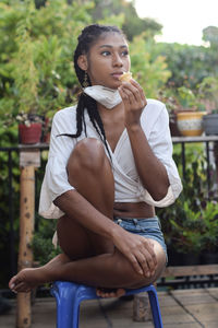 Young woman takes face mask off to enjoy an ice cream