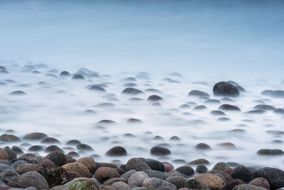 Rocks in sea against sky