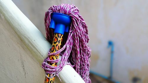 Close-up of cleaning mop by railing