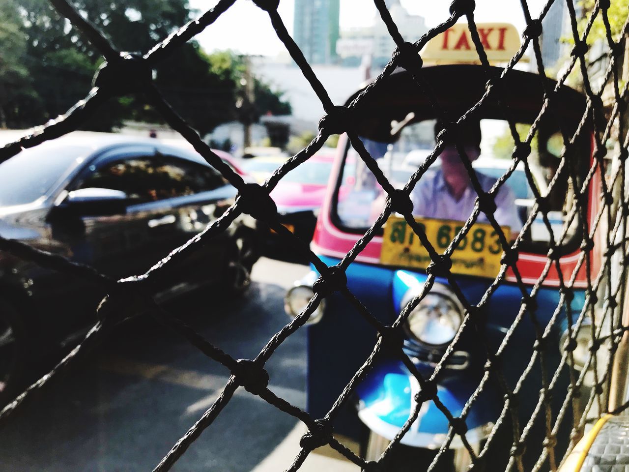 FULL FRAME SHOT OF CHAINLINK FENCE WITH CAR