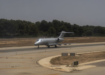 Side view of airplane on runway against sky