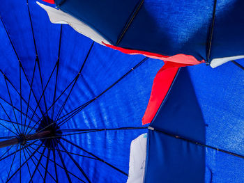 Low angle view of multi colored umbrella against blue sky