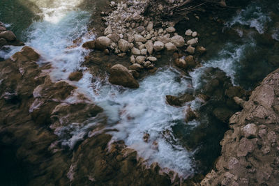 High angle view of stream flowing through rocks