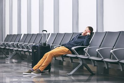 Man sleeping on chair at airport terminal