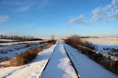 Snow covered landscape against sky