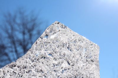 Low angle view of snow against clear blue sky