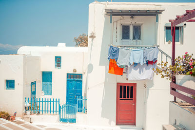 Clothes drying on building against blue sky