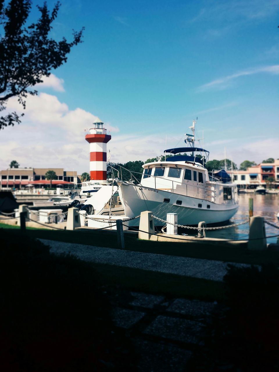 building exterior, architecture, transportation, built structure, sky, nautical vessel, moored, mode of transport, water, boat, sea, blue, cloud, cloud - sky, house, day, harbor, outdoors, sunlight, no people