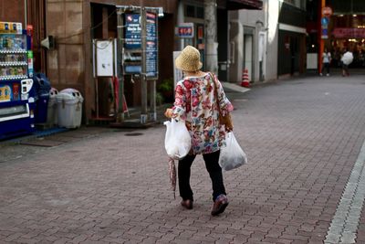 Full length rear view of woman walking in city