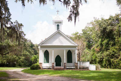 Trees by church against sky