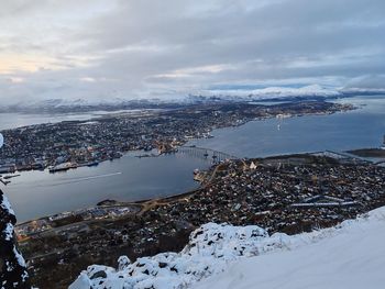 High angle view of city by sea against sky
