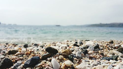 Surface level view of pebbles beach against sky