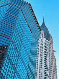 Low angle view of modern buildings against clear blue sky