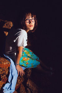 Full length of woman standing against blue wall