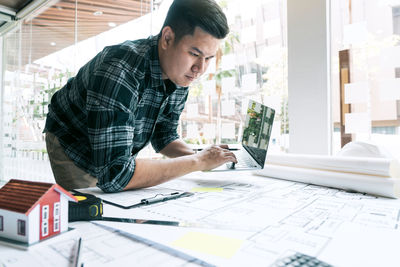 Man using mobile phone while sitting on table