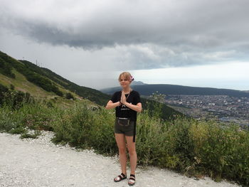 Portrait of girl standing with hands clasped on mountain