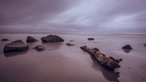 Rocks on sea shore against sky