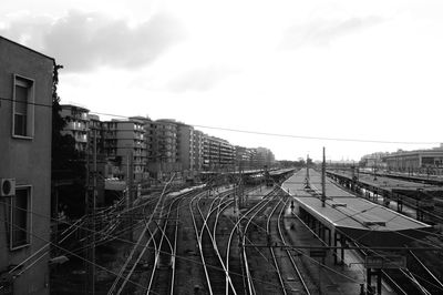 Railroad tracks in city against sky