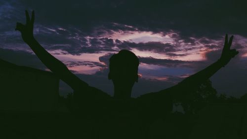 Silhouette woman standing against sky during sunset