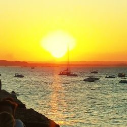 Sailboat sailing in sea at sunset