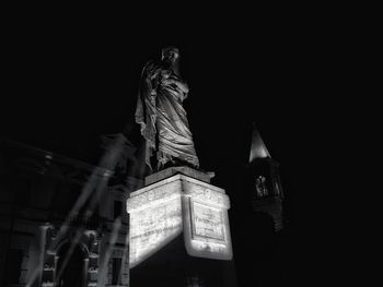 Low angle view of statue of historic building at night