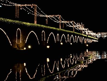 Low angle view of illuminated bridge at night