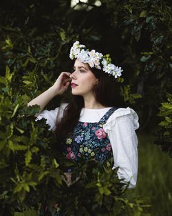 Portrait of a beautifull long hair woman with flower crown and flower dress in the woods in spring