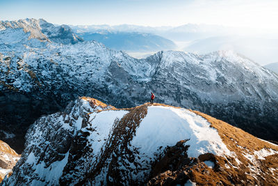 People on snowcapped mountain against sky