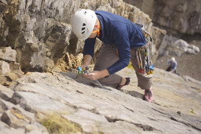 High angle view of man climbing rock by sea