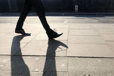 Low section of woman walking on footpath