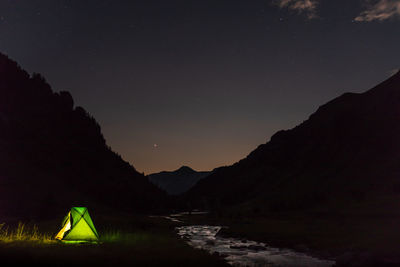 Scenic view of illuminated mountains against sky at night