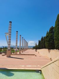 Low angle view of barcelona's olympics site and infrastructure against clear blue sky