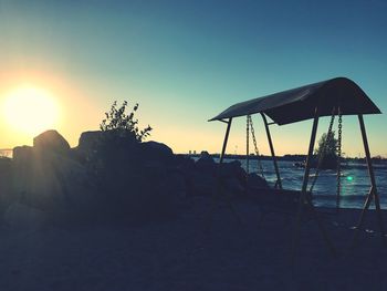 Silhouette beach against sky during sunset