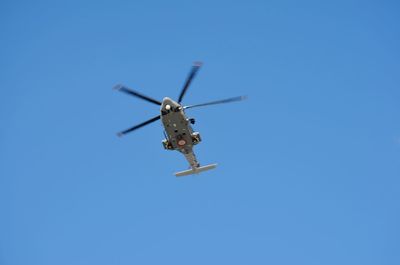 Low angle view of airplane against clear blue sky