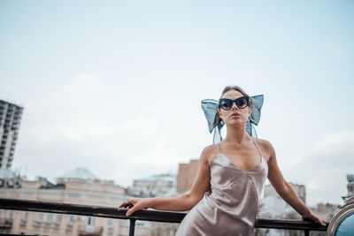 Young woman wearing sunglasses against sky