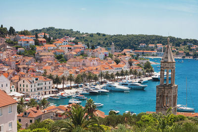 Aerial view of townscape by sea against sky